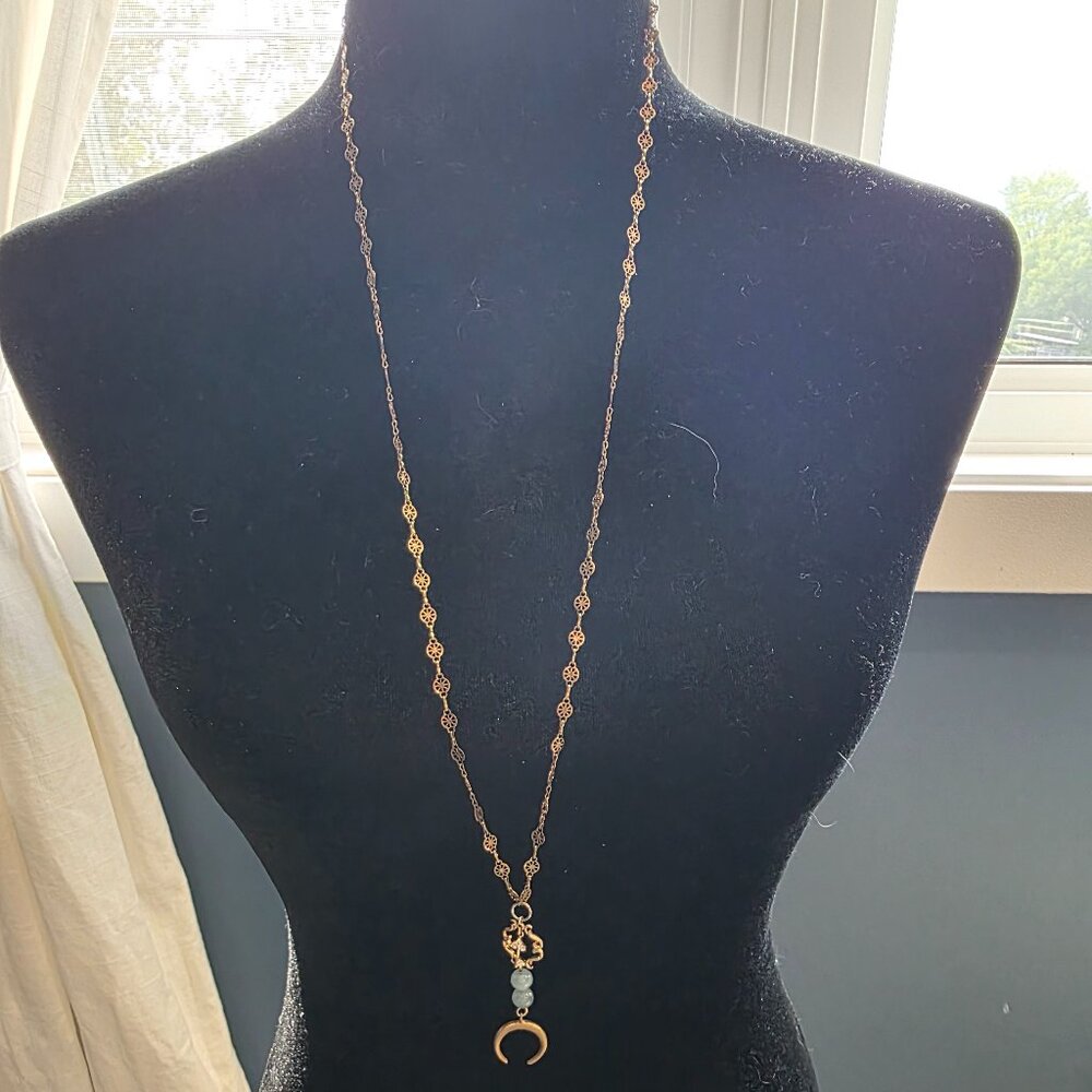 Long gold necklace with crescent moon and small key pendant